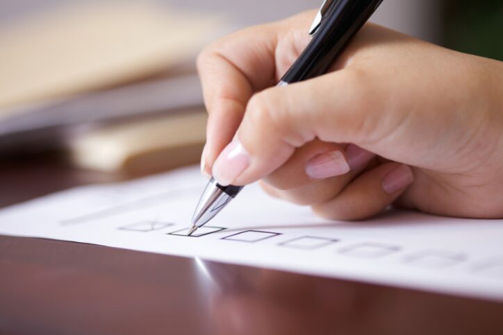 Close-up of a hand writing on a document.